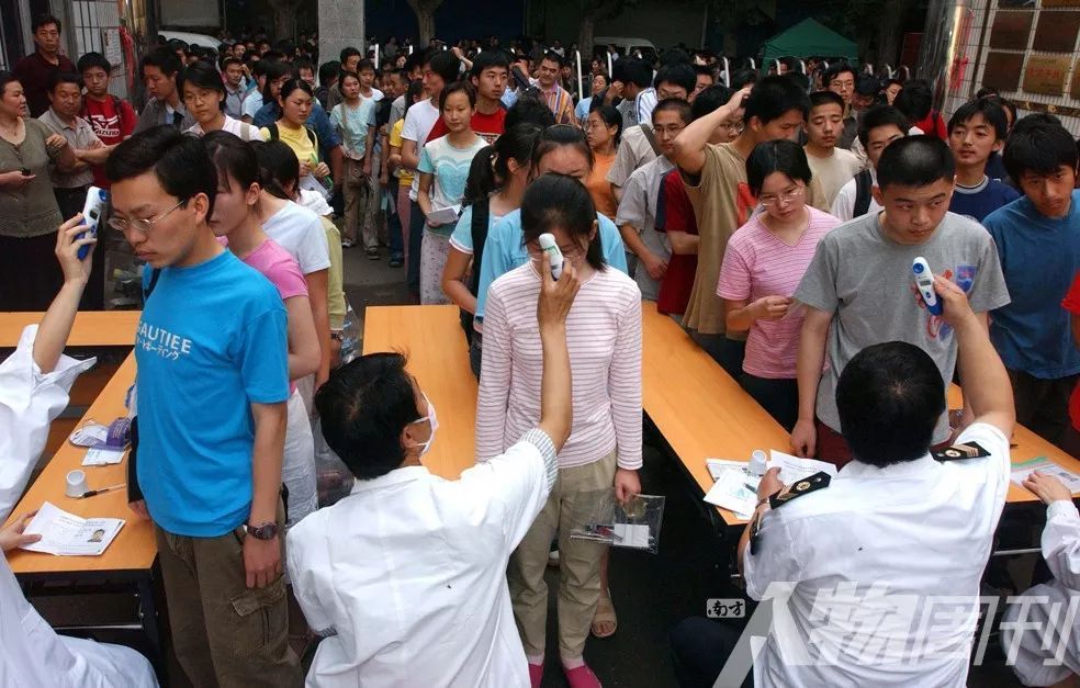 2003年6月7日，郑州一个高考点，考生入场前接受体温检测   图 / 小白
