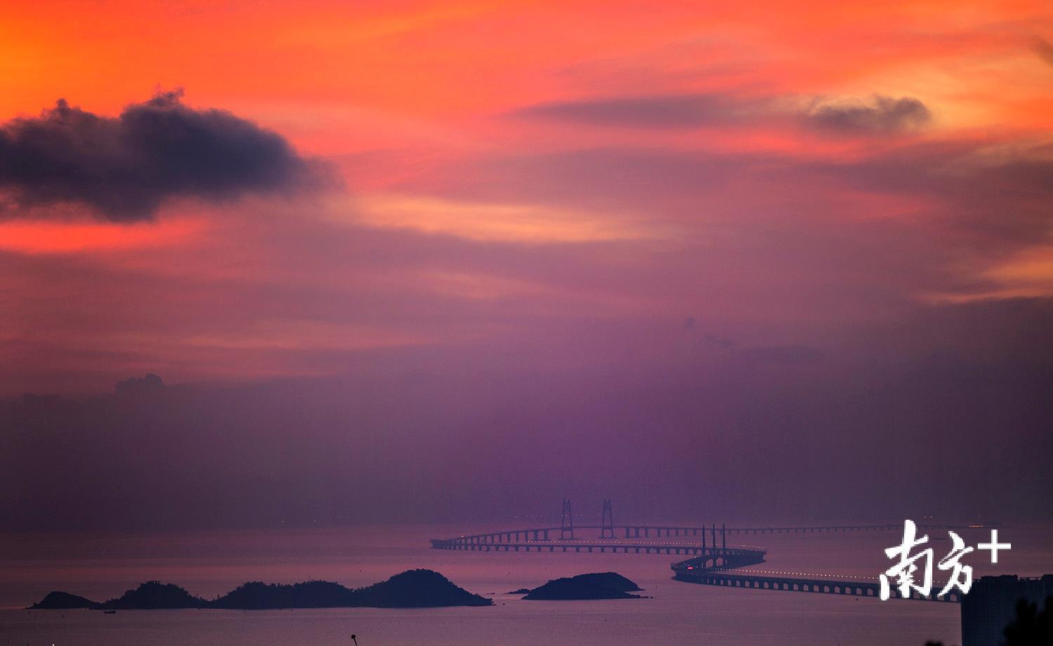 △朝霞满天，天空如油画一般，港珠澳大桥置身于其中。