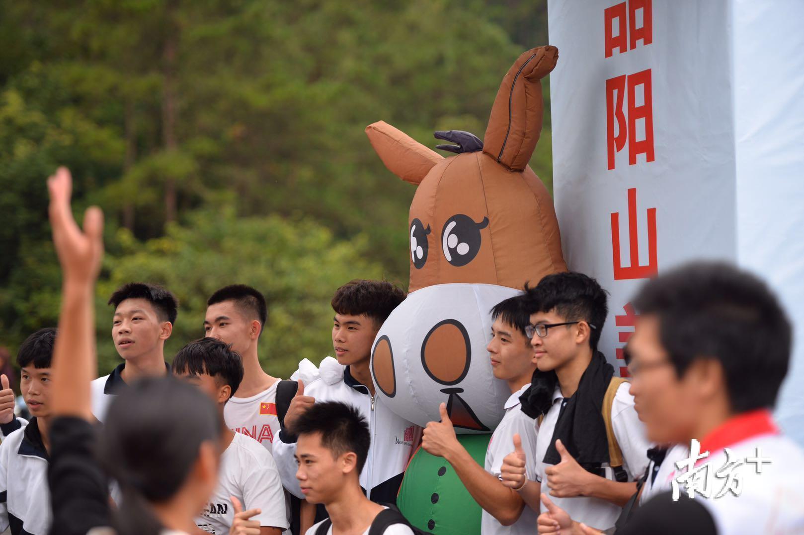 本次徒步嘉年华吉祥物“阳驴山仔”受到了年轻学生们的追捧，争相合影留念。