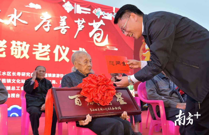三水区副区长方小兵为冼四妹颁发“百岁寿星”牌匾,并送上百岁老人慰问金。/李东摄 三水区副区长方小兵为冼四妹颁发“百岁寿星”牌匾,并送上百岁老人慰问金。/李东摄