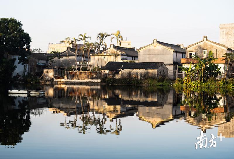 池塘水平如镜，荡漾着四周潮汕古民居的倒影