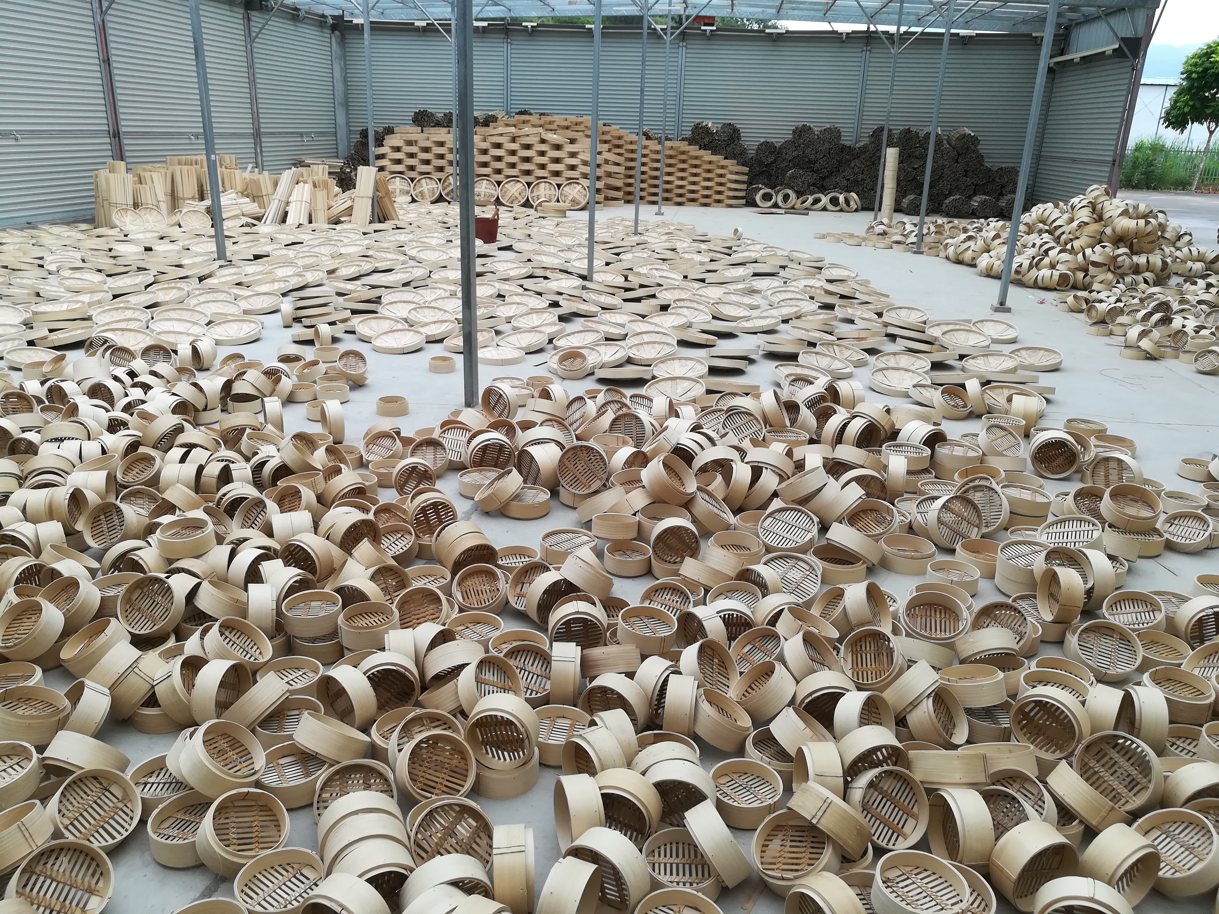 恒兆蒸笼生产基地的遮阳棚下,数千个成品蒸笼正在晾晒。(谢庆裕摄影) 恒兆蒸笼生产基地的遮阳棚下,数千个成品蒸笼正在晾晒。(谢庆裕摄影)