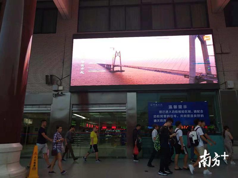 港珠澳大桥建设期间的帧帧画面在出境大厅门口的大屏幕上闪过