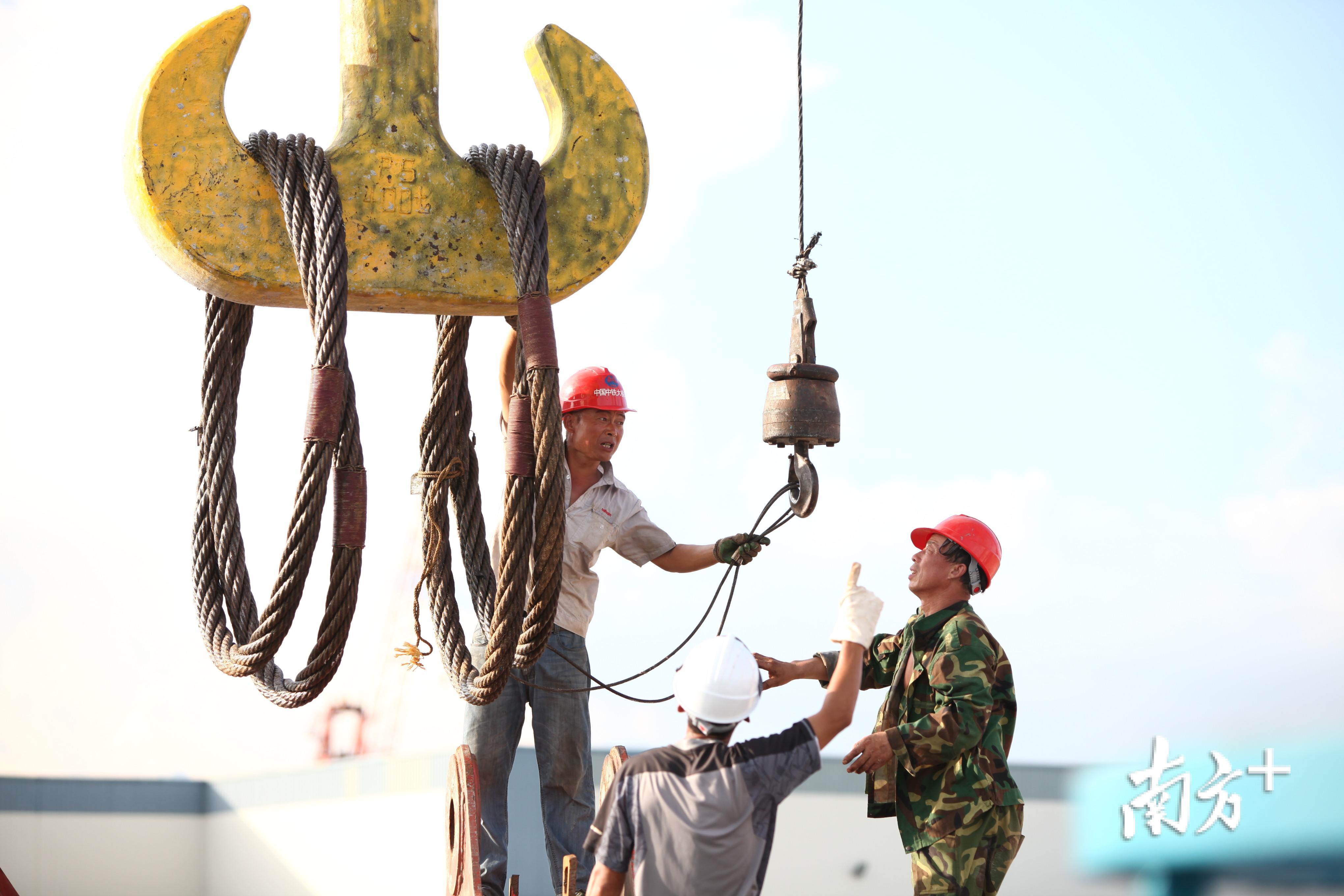 2014年6月，工人们正在用龙门吊起吊重达50吨的钢梁