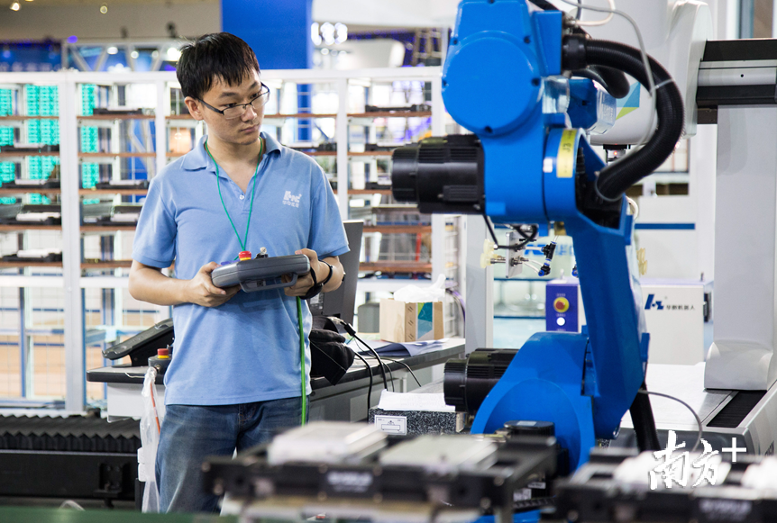 劲胜智能的技术人员正在调试机械手.