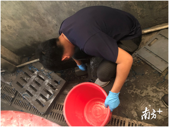 环境监测人员在直排下水道口取样监测