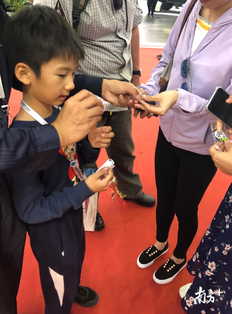 杨先生正带着儿子和游客交换徽章