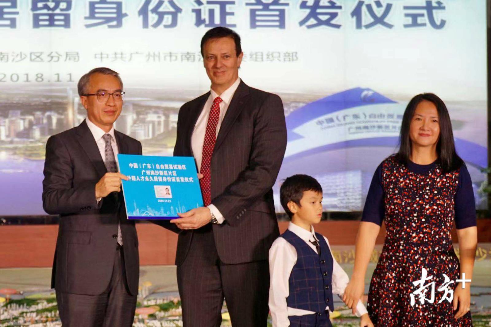 广州市委常委、南沙区委书记蔡朝林为Eames Mark一家三口发放外国人永久居留身份证。