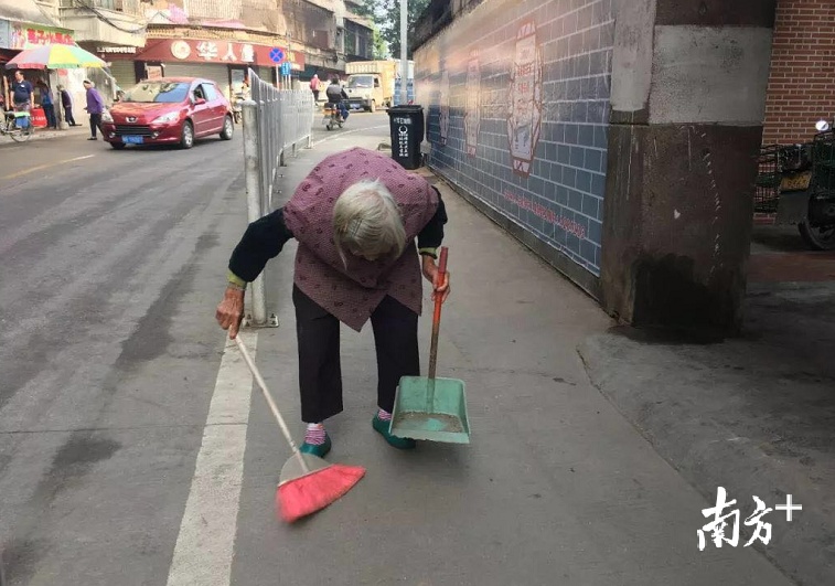 廖阿婆佝偻着腰扫街，腰和地面快平行了。