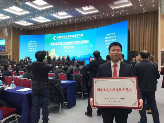 12月15日上午，龙门县委书记陈伟良接受国家生态环境部领导授予的“国家生态文明建设示范县”牌匾。