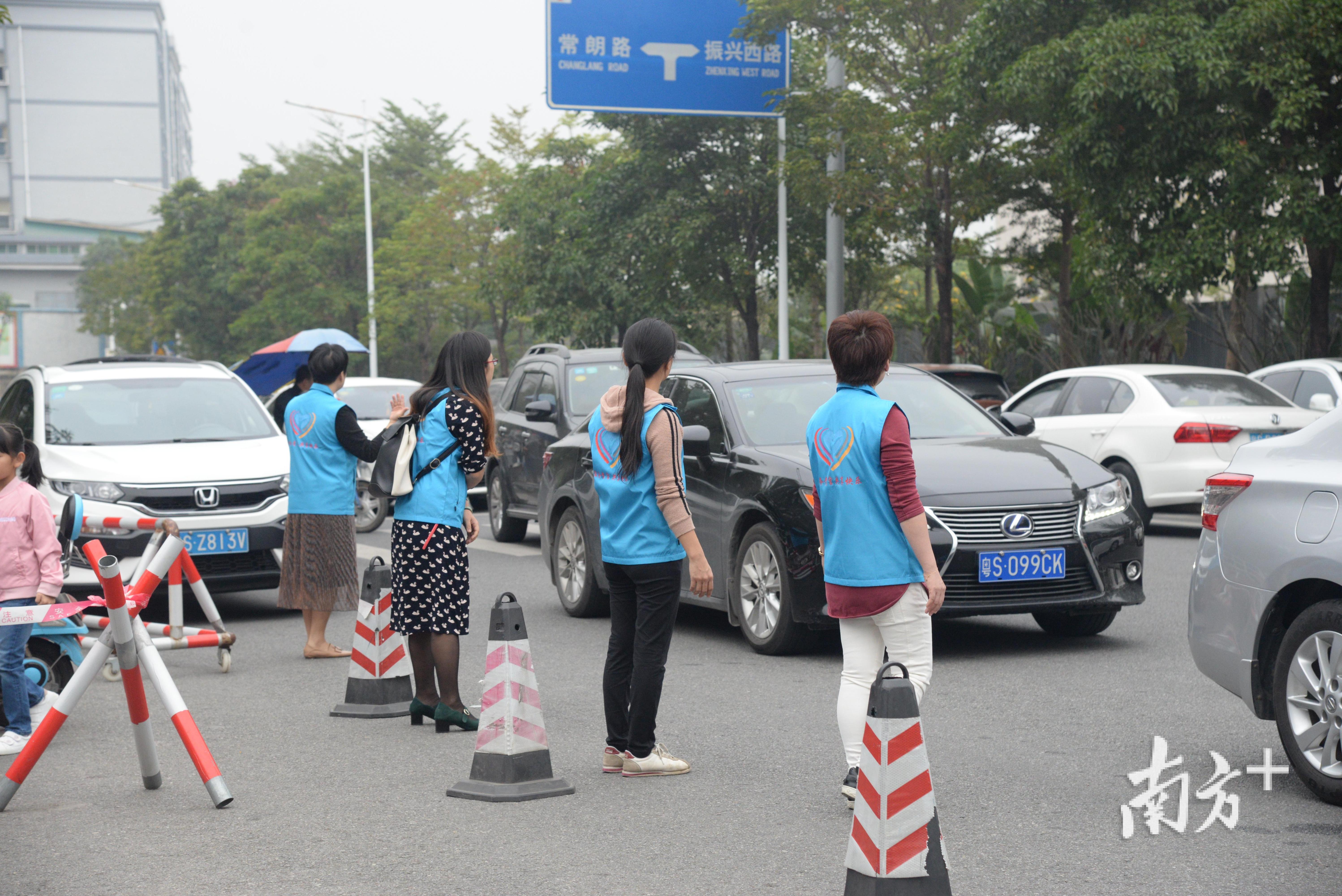 接送高峰期家长志愿者在少年宫门外维护秩序。