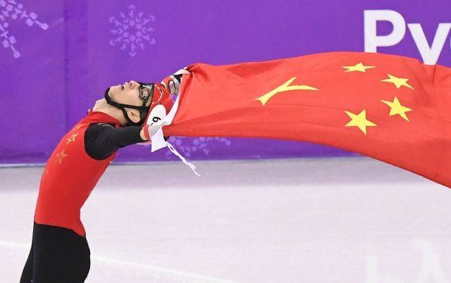 武大靖在平昌冬奥会短道速滑男子500米决赛夺冠后手持国旗庆祝