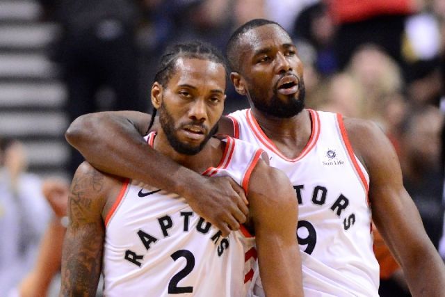 猛龙队球员伦纳德(左)与伊巴卡在比赛中.