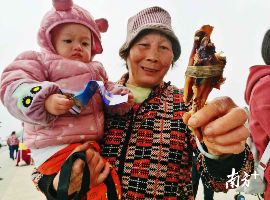 市民在品尝腊鸭扎。