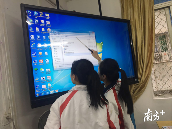 如今,城西中学的教室里配置了智能电脑系统。图为学生们课后自行拷贝课件。