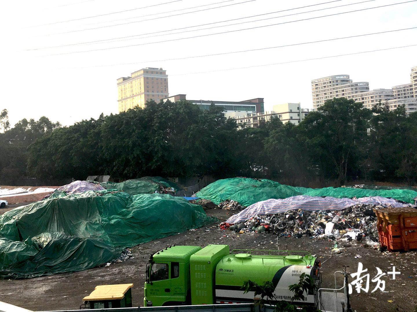 大部分垃圾都已被遮盖,一辆环卫车正在喷水处理 大部分垃圾都已被遮盖,一辆环卫车正在喷水处理
