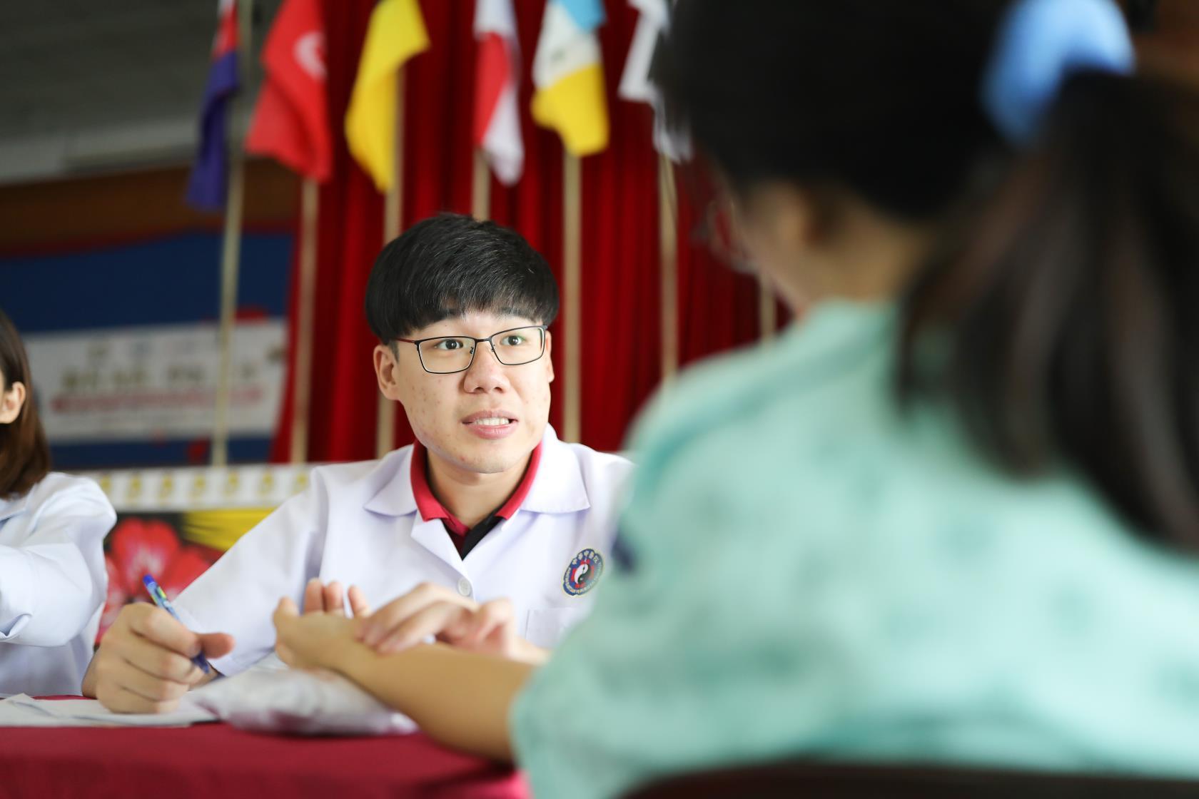 英迪国际大学中医系的学生正在问诊。