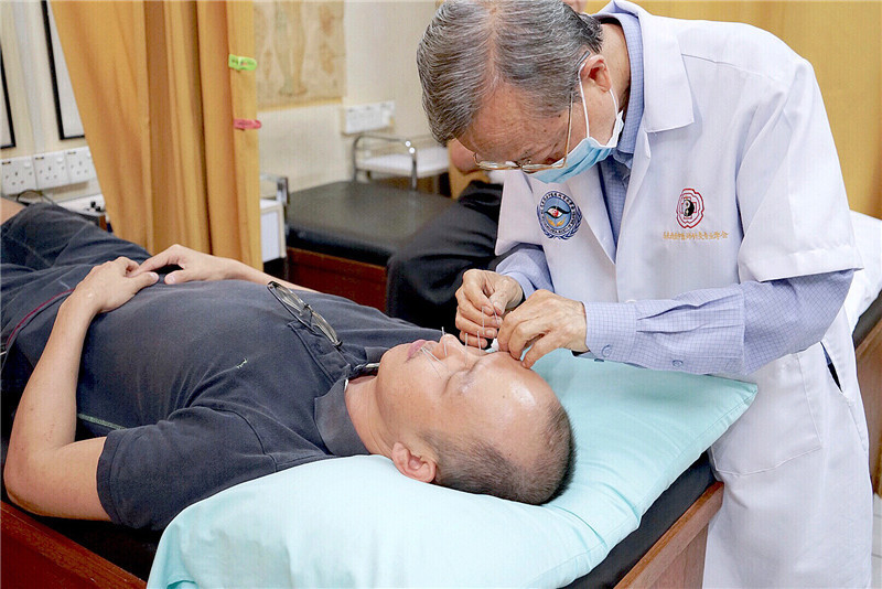 谢奇正在用深针疗法为一位患者治疗眼疾