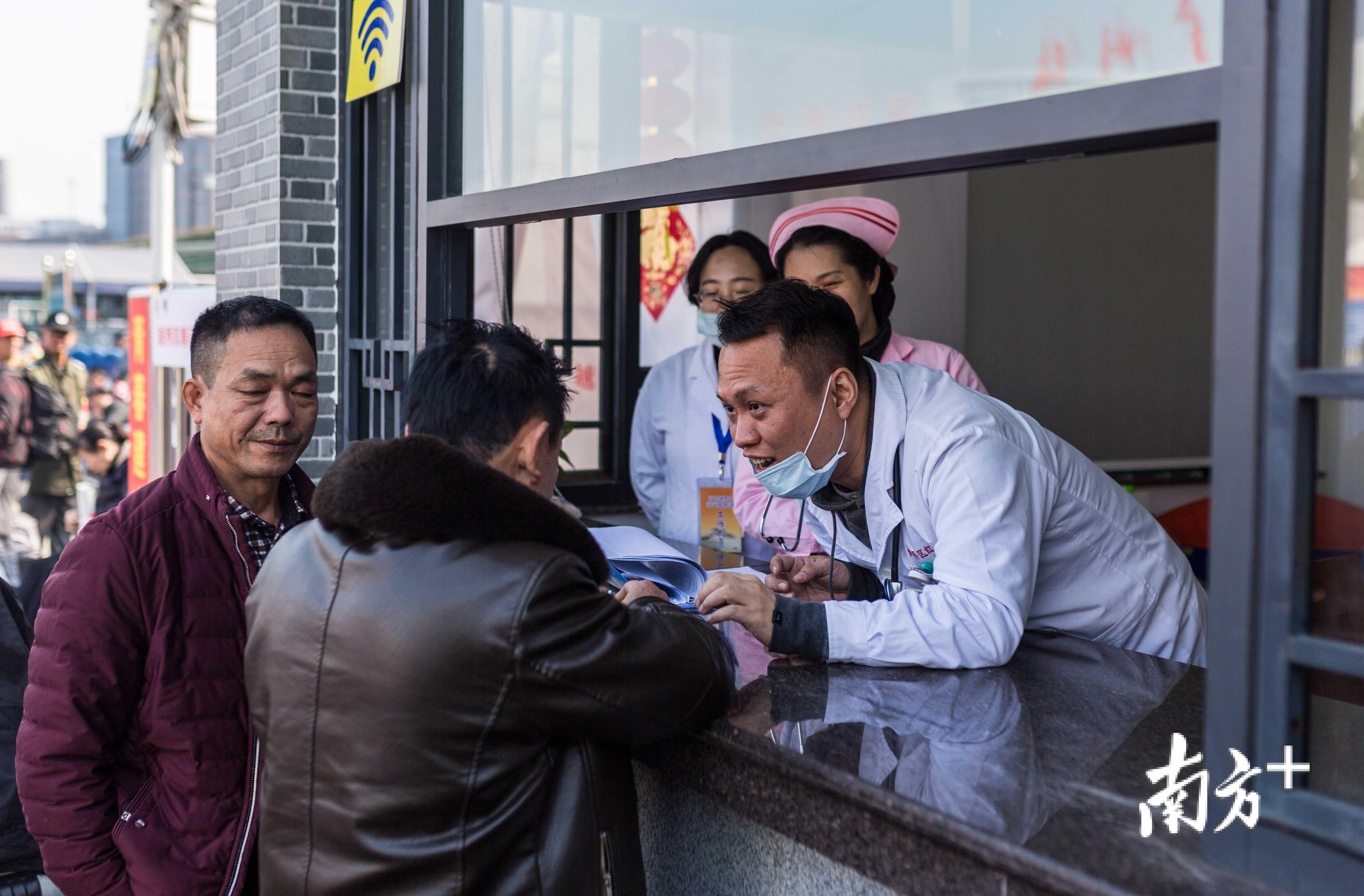 火车站前广场西侧的医疗点处，工作人员正建议乘客如何防感冒。
