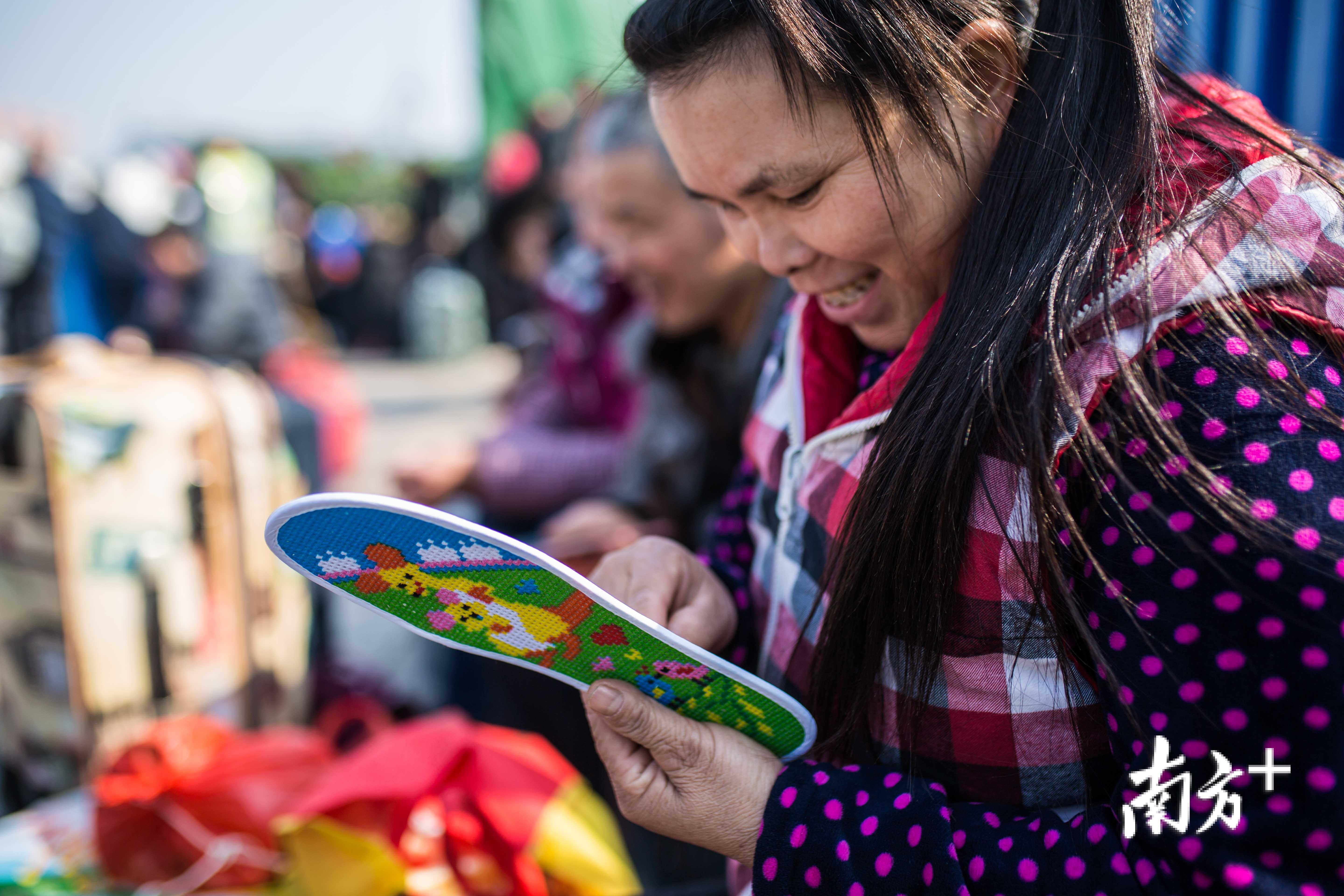 一位重庆的旅客，正在广场上绣鞋垫打发候车时间。