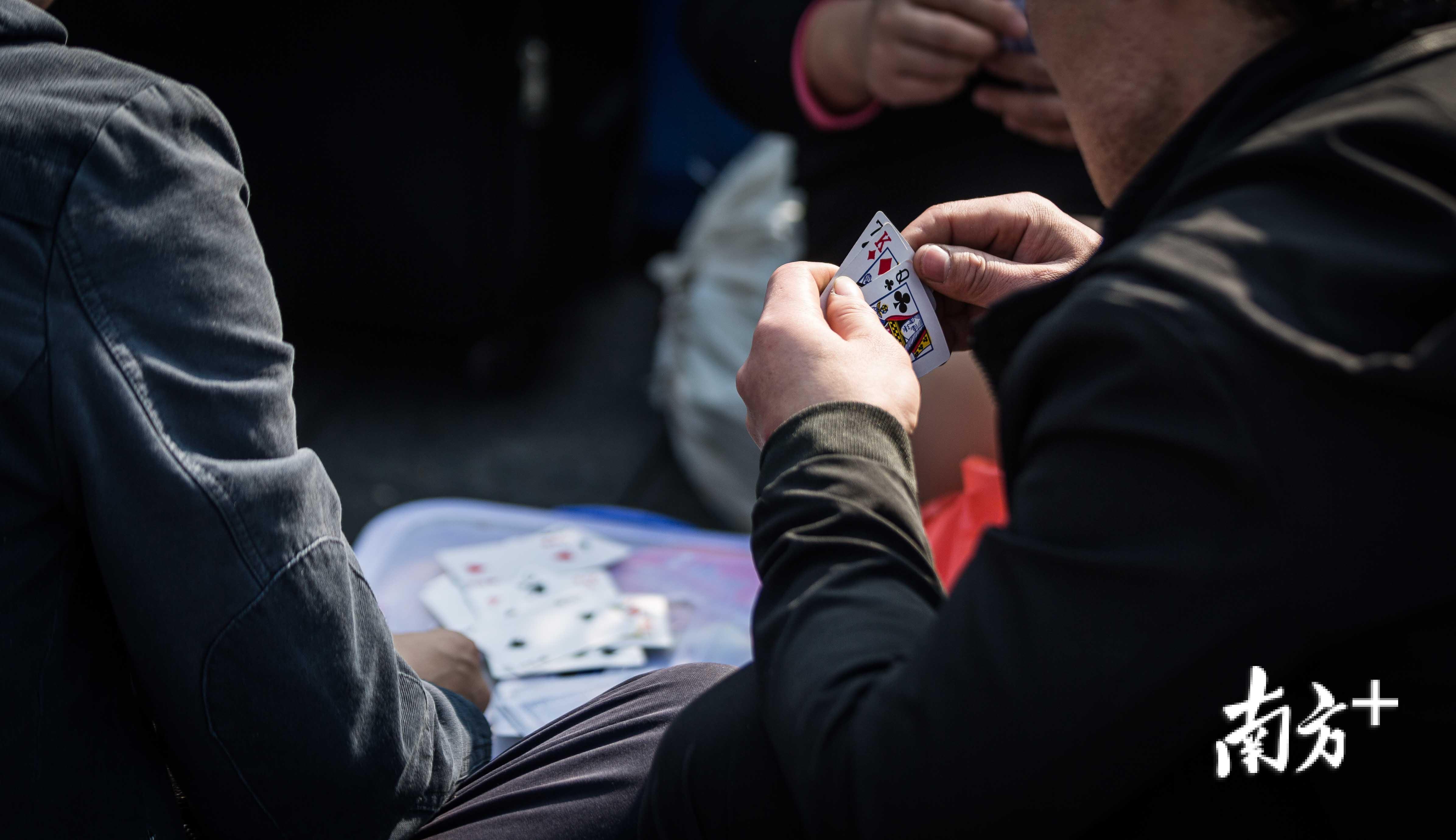 火车站广场上，扑克牌一直是最常见的消遣方式。
