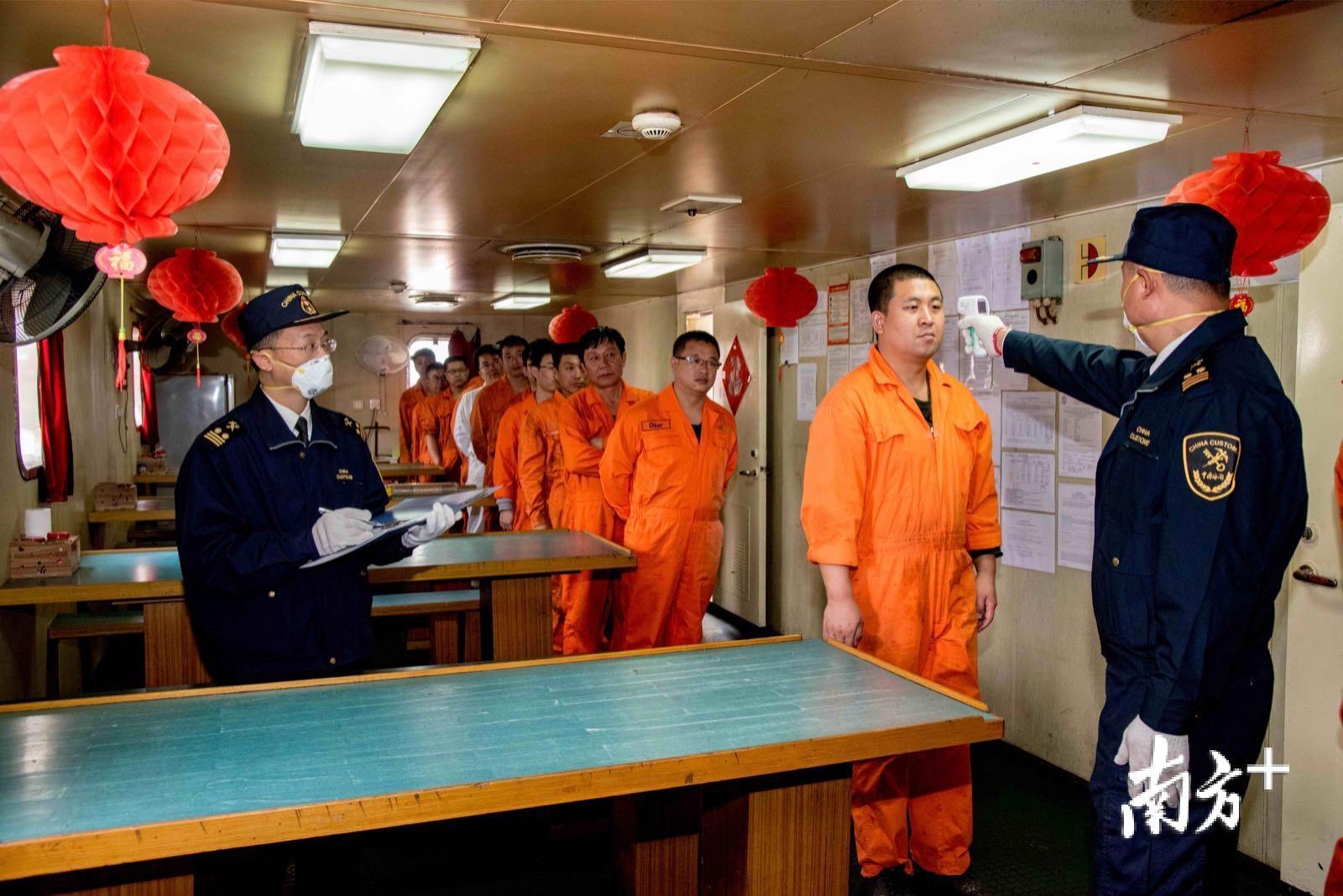 海关查验人员对船员逐一进行体温测量。袁国宏 摄