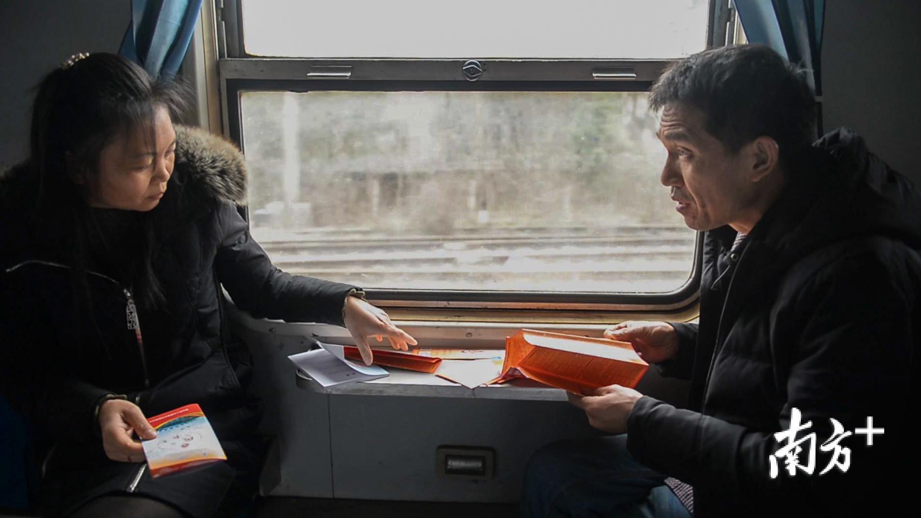 △吴仁明和妻子仔细翻阅招聘宣传册。