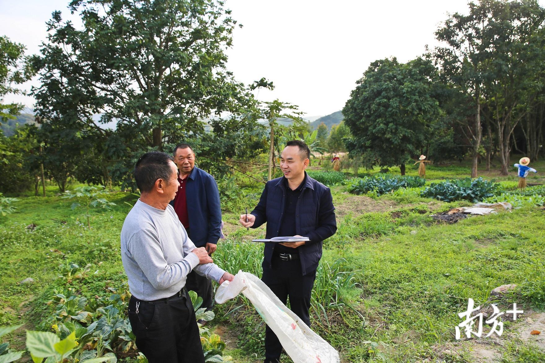 驻下村村工作组长徐名阁深入田间地头与群众交流。（胡金辉摄）