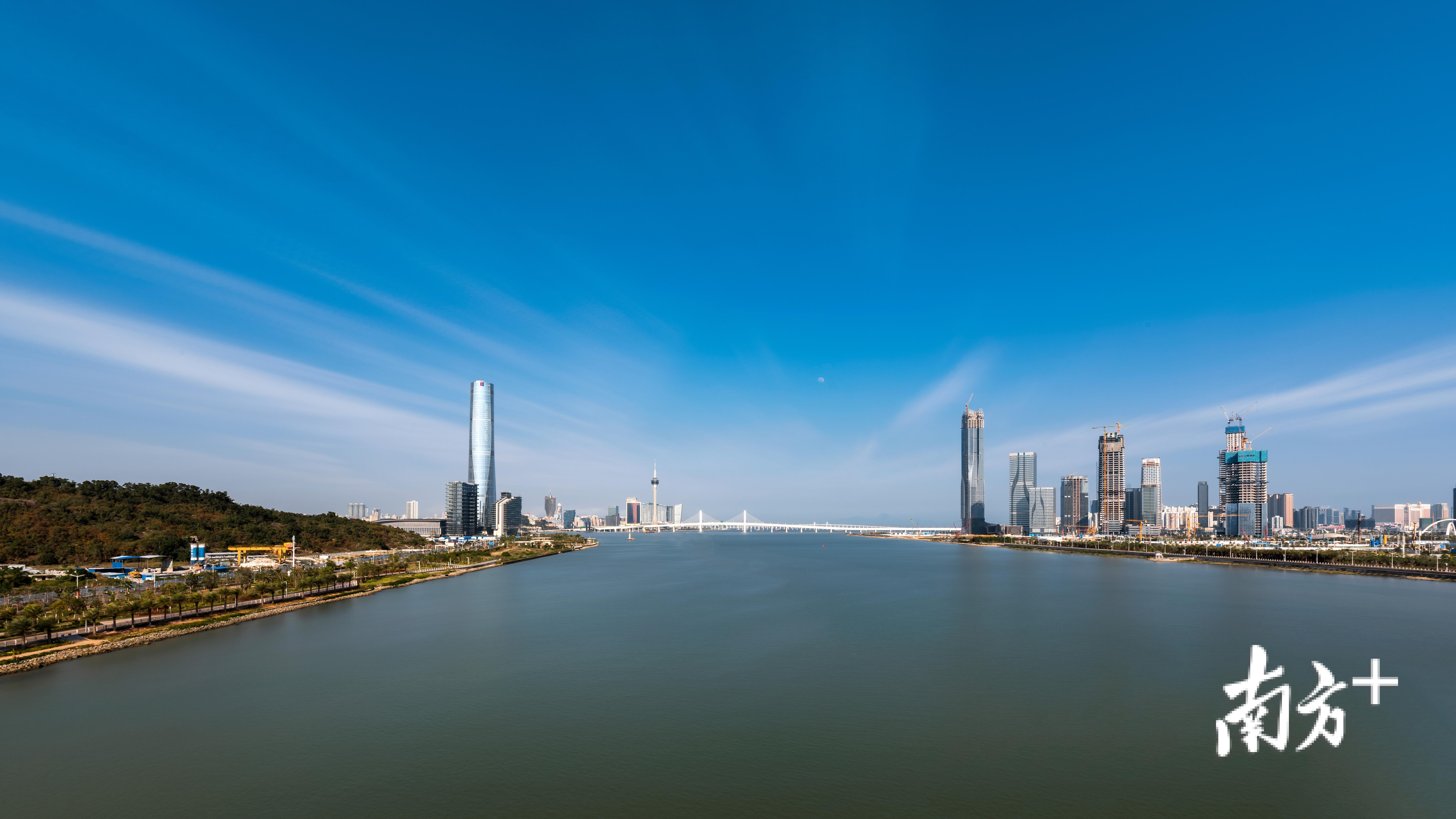 一河两岸，左边为珠海十字门中央商务区，远处为澳门，右边为珠海横琴自贸区，2019年2月18日，中央发布了粤港澳大湾区发展规划纲要。吖震 摄