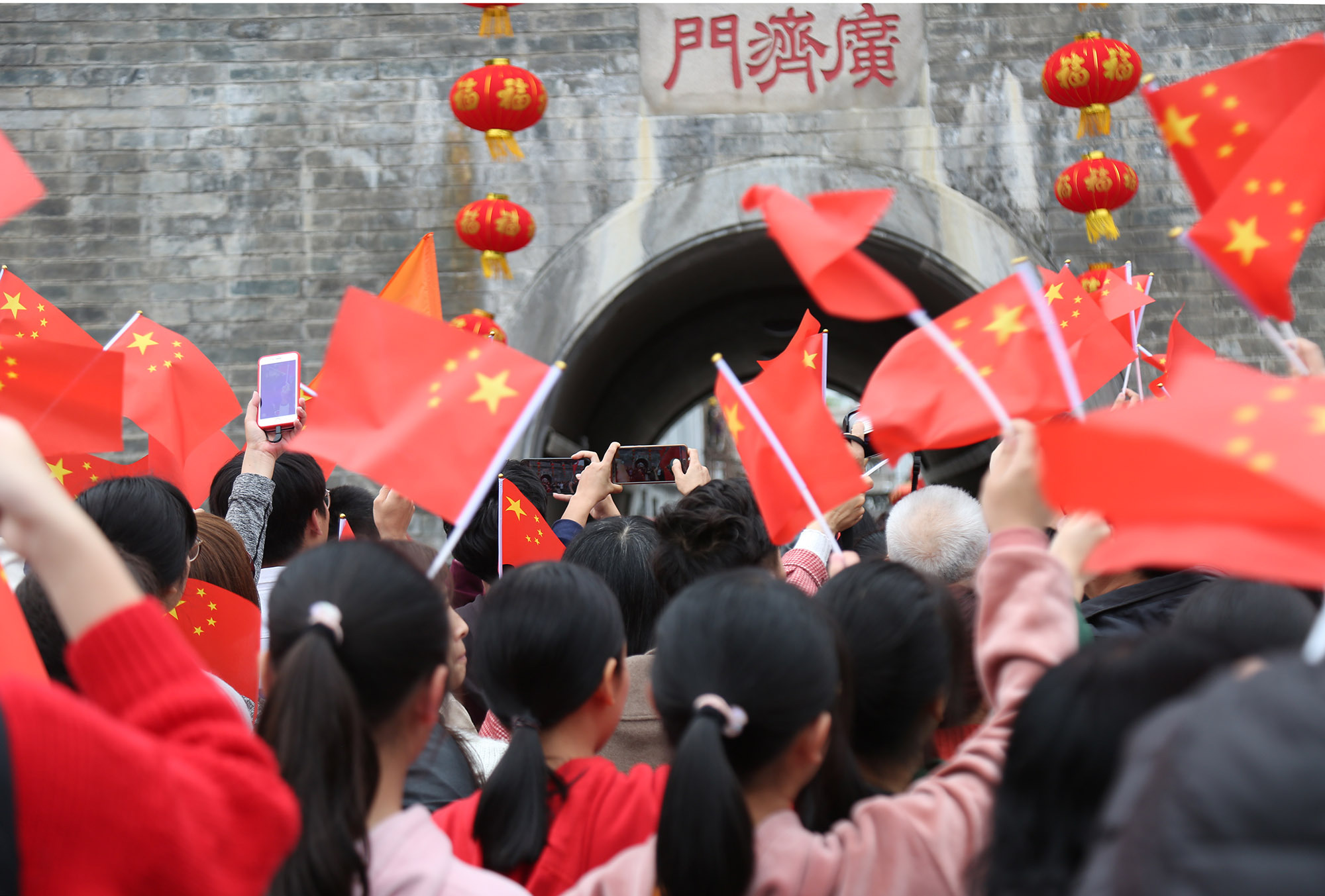 2月26日下午，广济门前，市民游客挥舞着国旗，共同唱响《我和我的祖国》。