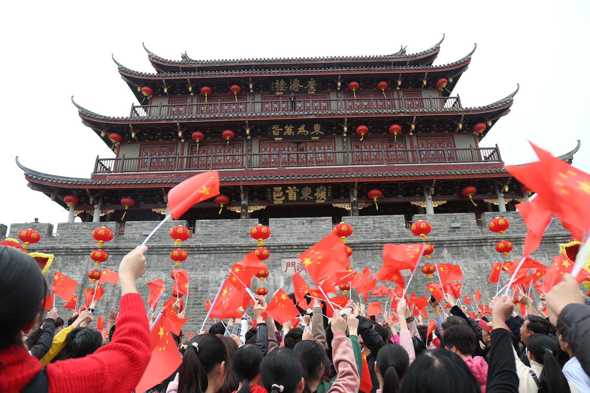 2月26日下午，广济门前，市民游客挥舞着国旗，共同唱响《我和我的祖国》。