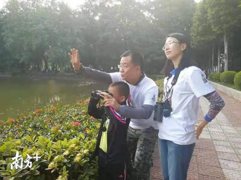 李宇红夫妇一起指导小朋友观鸟。鄢智勇 供图