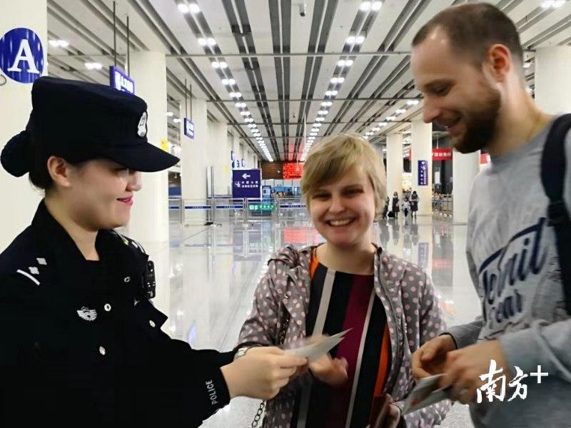 边检民警李波热情为外国籍旅客服务。