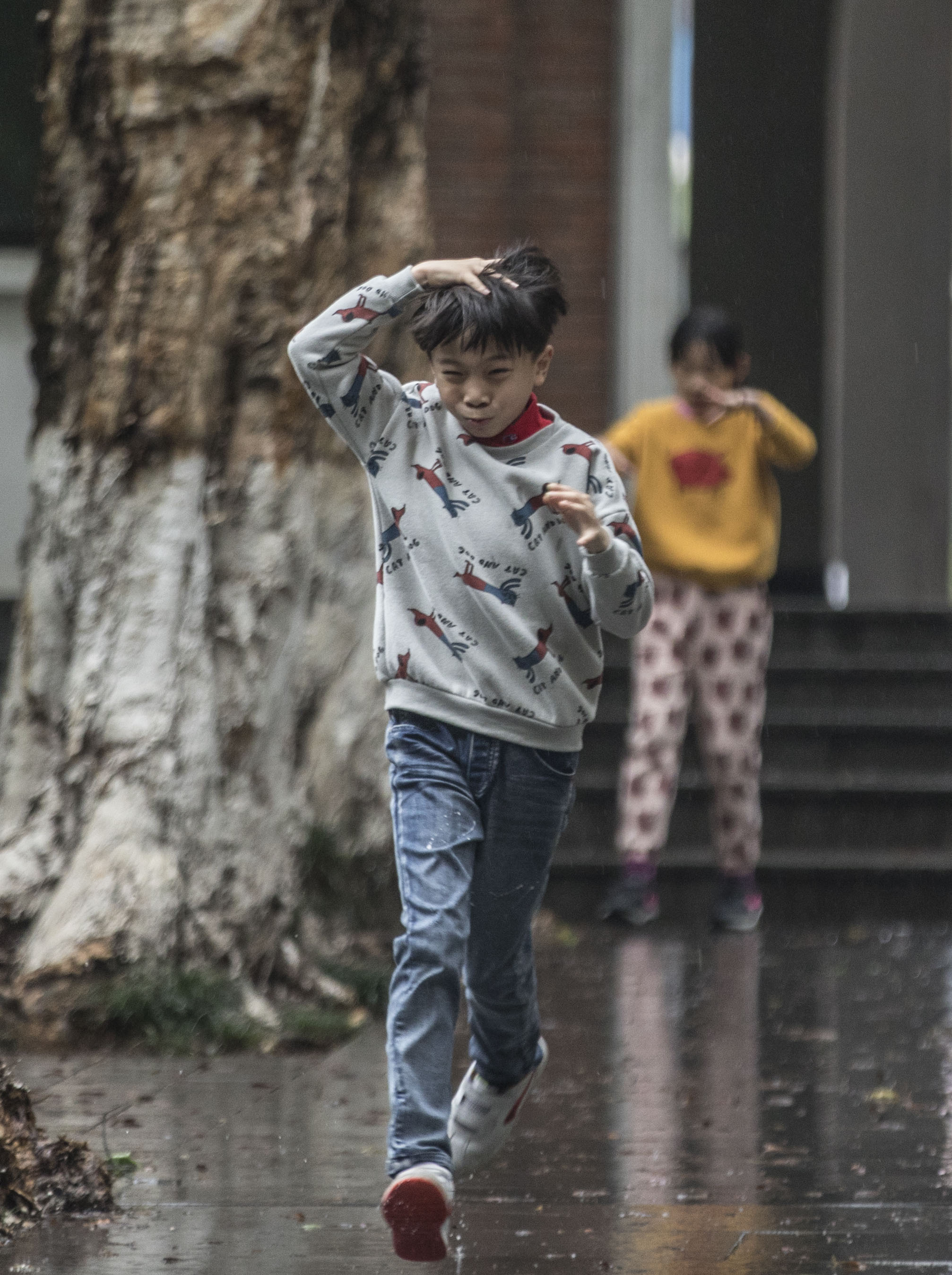 昌岗东路美院里小朋友在雨中奔跑.