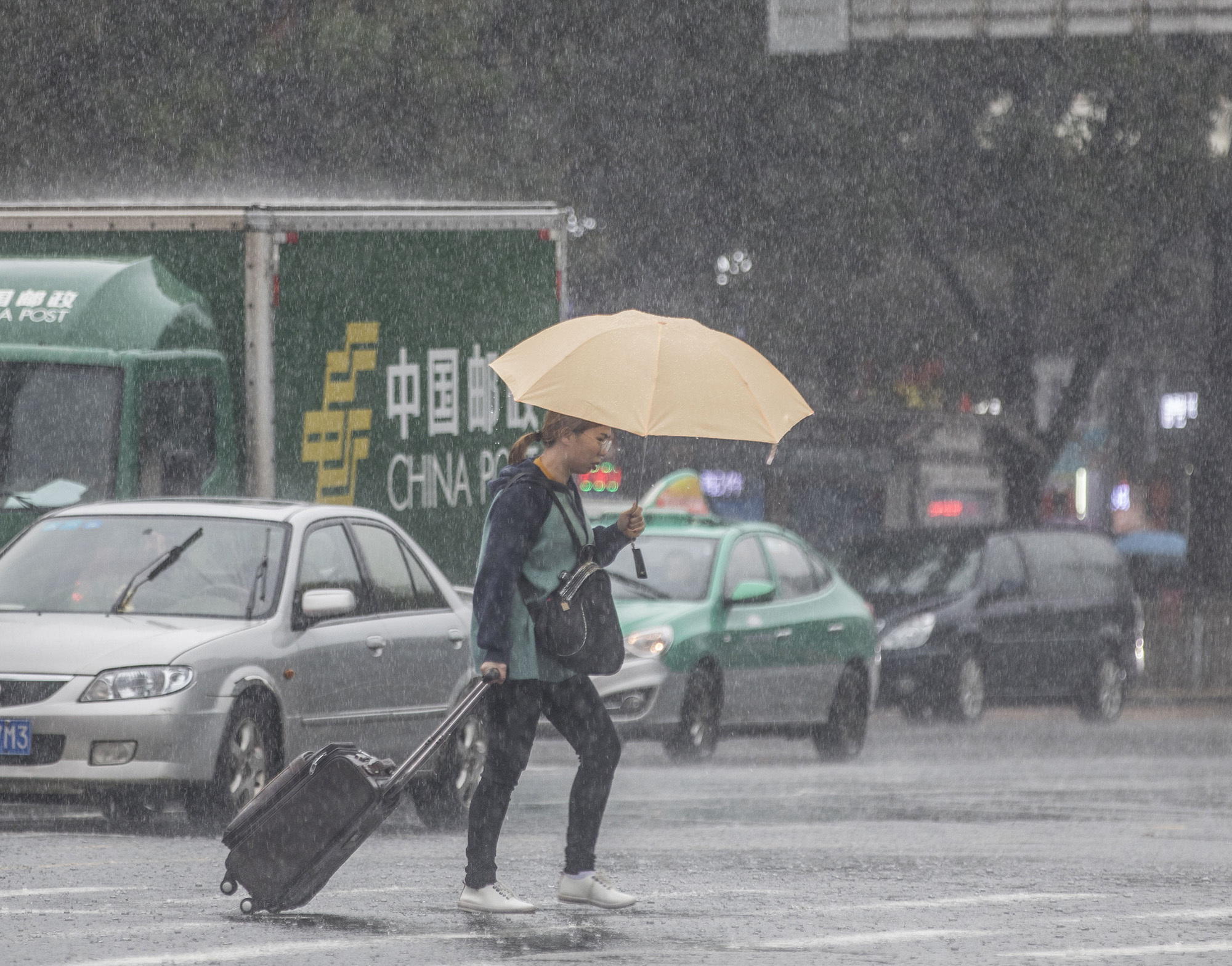 昌岗十字路口附近市民打伞匆匆过马路.