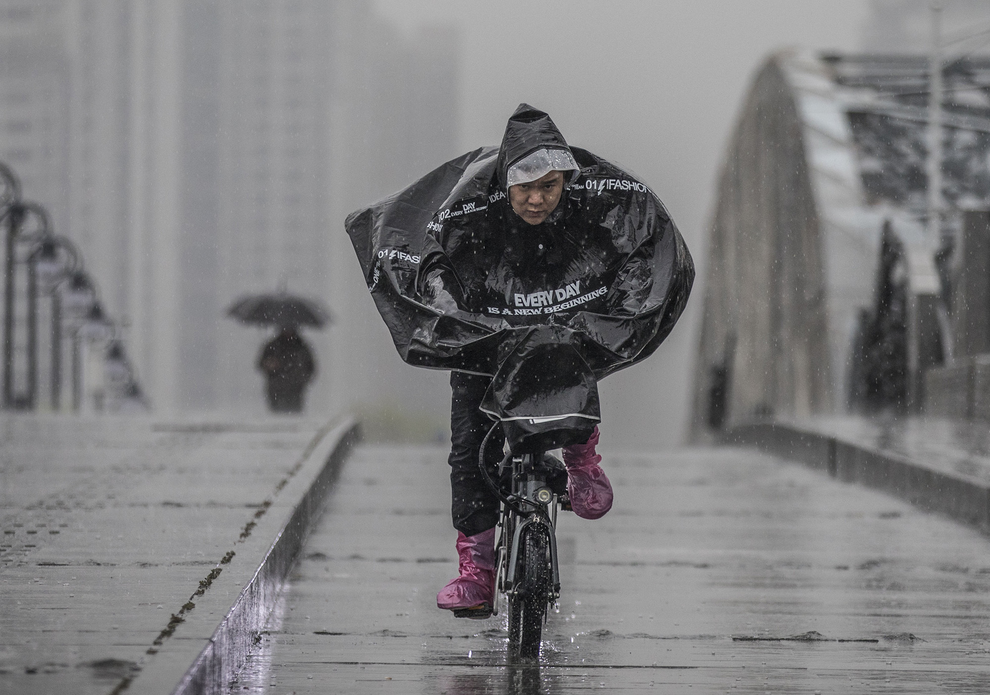 海珠桥上市民骑车冒雨而过