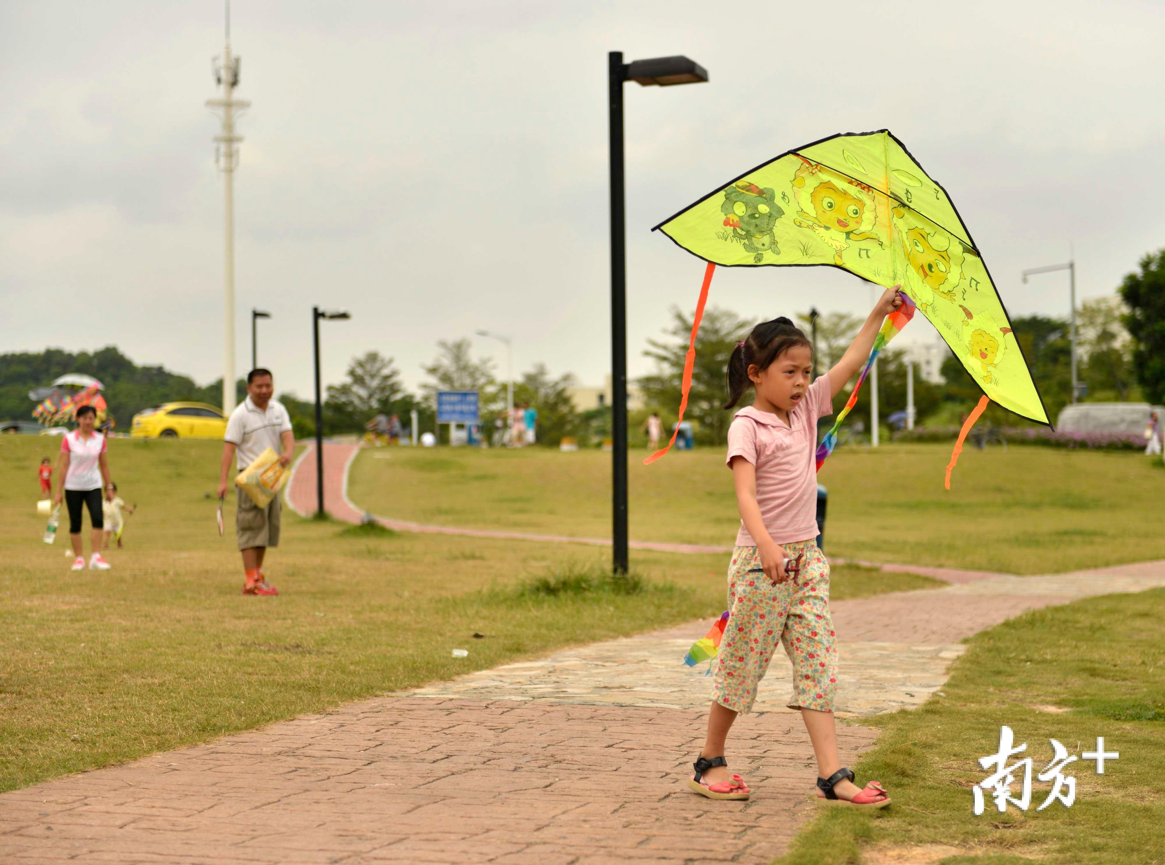大学城中心湖环境优美,成了许多学生和市民休闲游玩的好去处,一小朋友在绿道放风筝。(肖雄 摄) 大学城中心湖环境优美,成了许多学生和市民休闲游玩的好去处,一小朋友在绿道放风筝。(肖雄 摄)