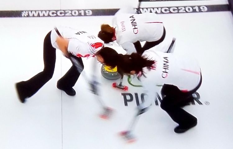 与俄罗斯队交手时，中国队三人奋力擦冰