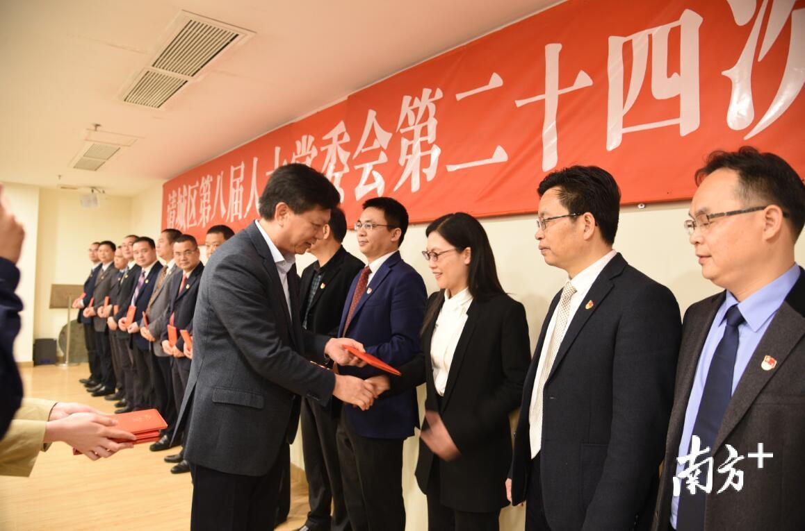 清城区人大常委会主任李灿坚为新任命区政府组成部门“一把手”颁发任命证书。 黄玉熹摄