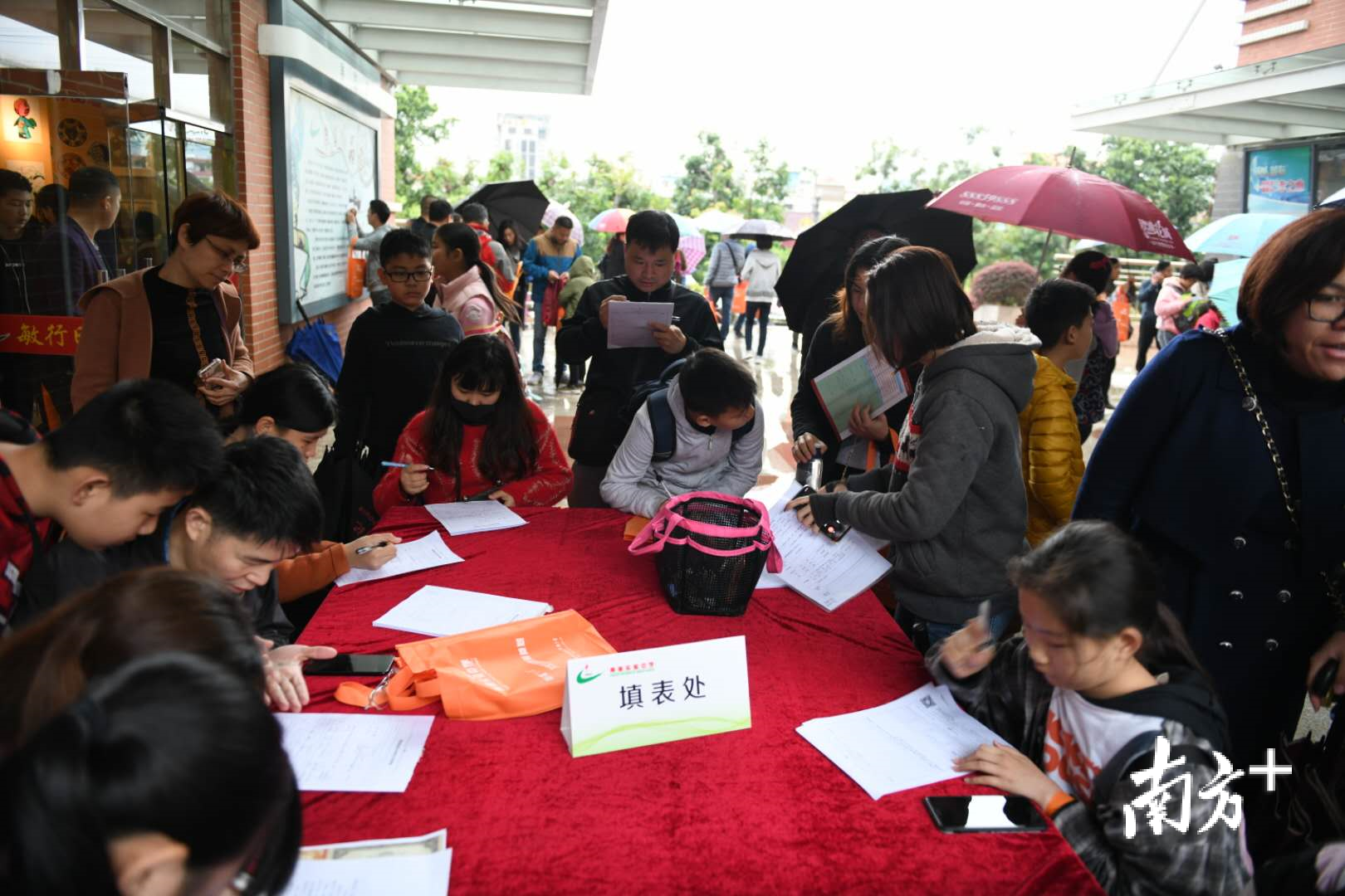 家长们在填表处聚集,为孩子的小升初做准备。 家长们在填表处聚集,为孩子的小升初做准备。