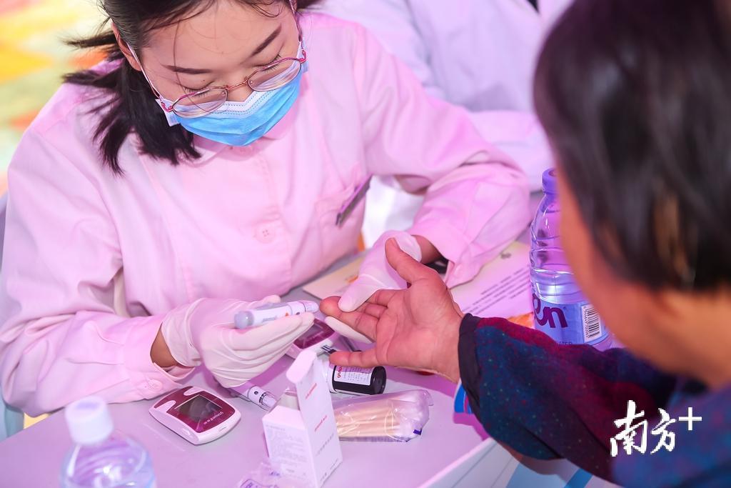 护士细心为患者测量血糖.