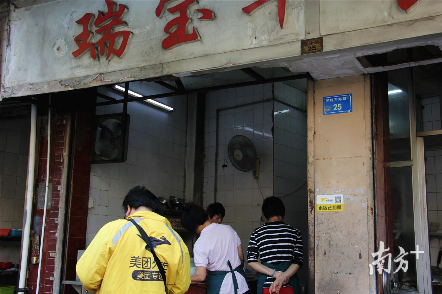 美团骑手正在瑞宝门前等外卖