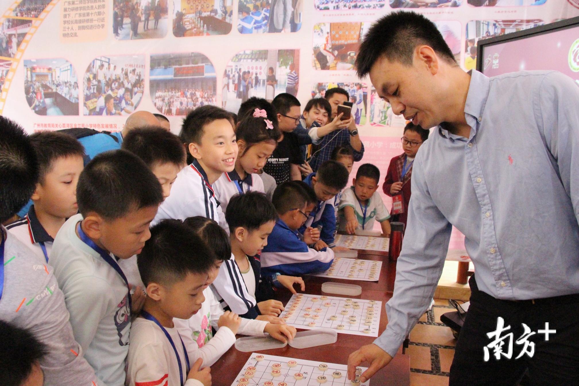 象棋特级大师许银川正与学生们切磋棋艺。