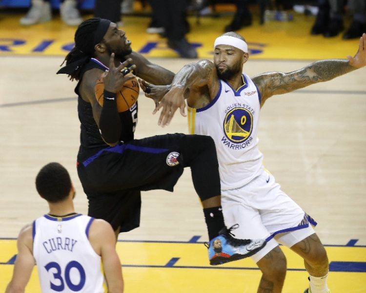 勇士队球员德玛库斯·考辛斯（右）防守快船队球员哈雷尔。新华社发（董旭东摄）