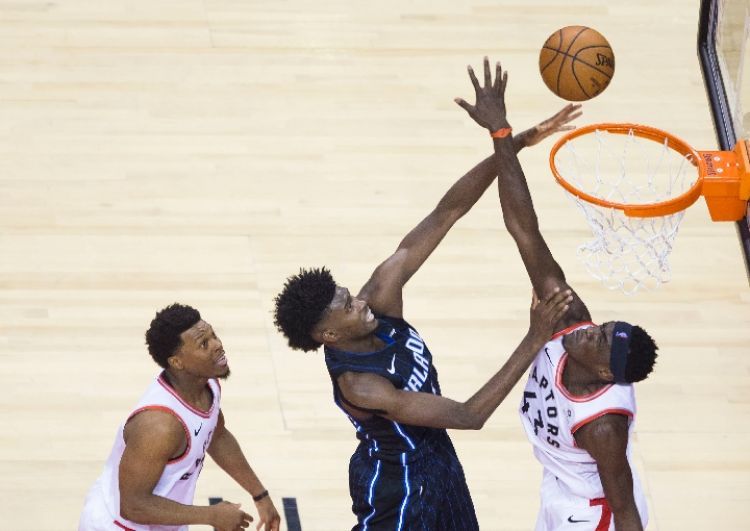 魔术队球员乔纳森·艾萨克（中）在比赛中上篮。 新华社发（邹峥摄）