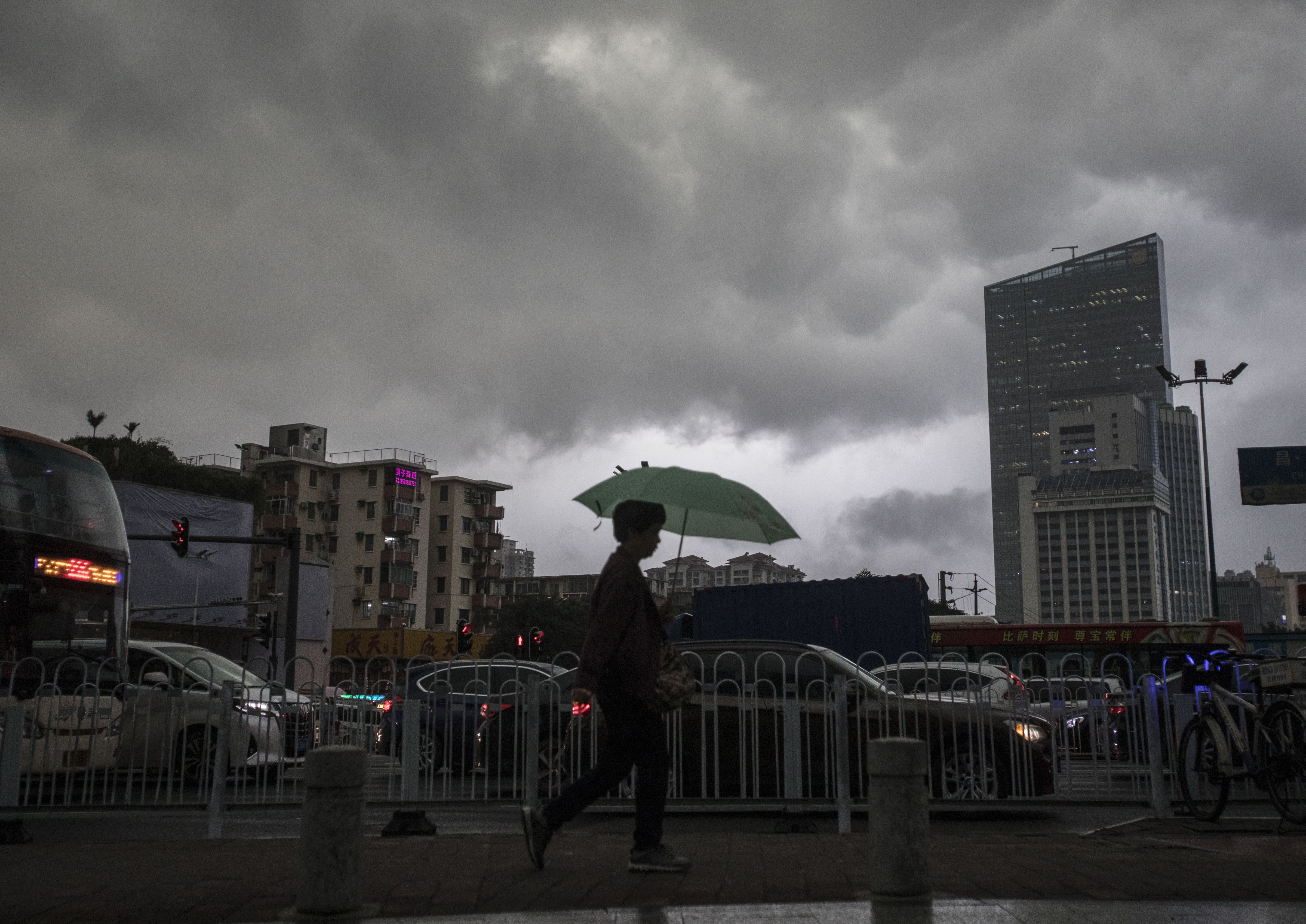 海珠区江南大道及晓园路附近市民打伞在暴雨中艰难行走.