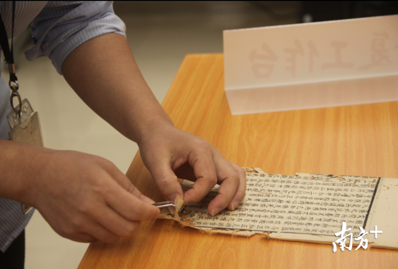 张月兰用镊子轻轻揭开破损的书页。