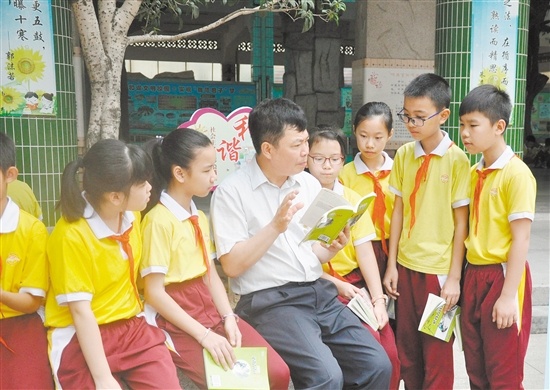 范罗冈小学校长和孩子们一起读书。  