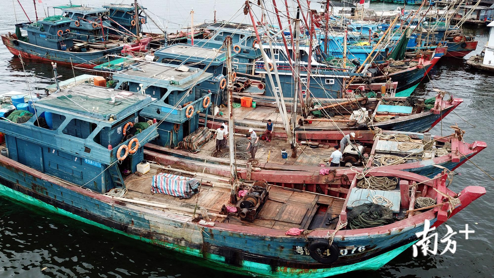 图为渔民正在对渔船进做相关安全措施。