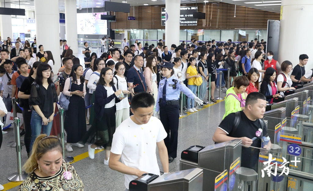 边检民警在福田口岸出境大厅自助查验区域引导旅客快速通关。黄俊生/摄